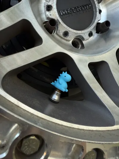 Image 2 : Bouchons de valve en forme de petit dino sur une jante (photo 2)